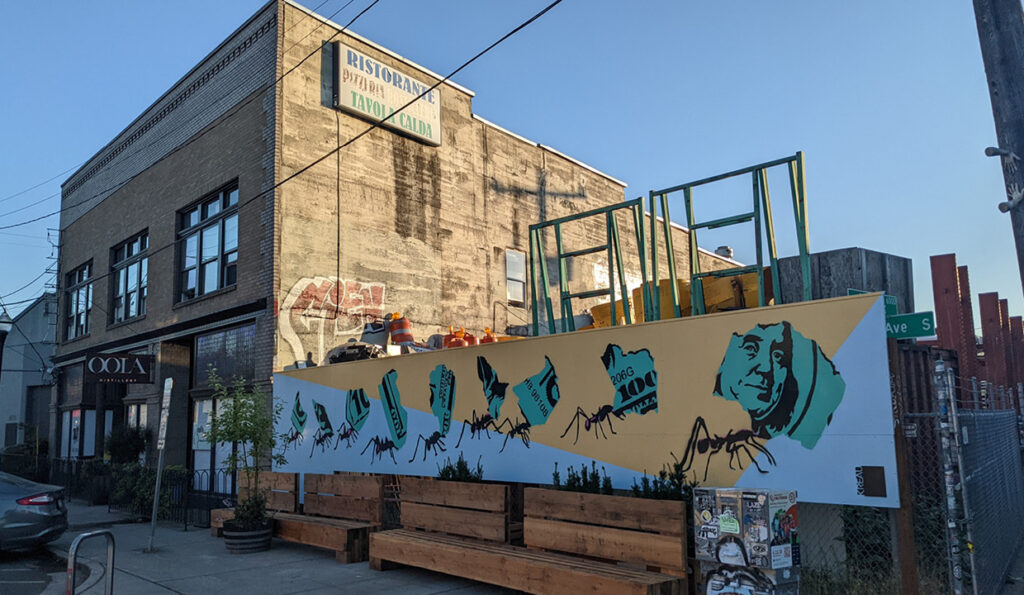 georgetown_01 wide view of stencil mural, 9 leaf cutter cants carrying torn pieces of a hundred dollar bill